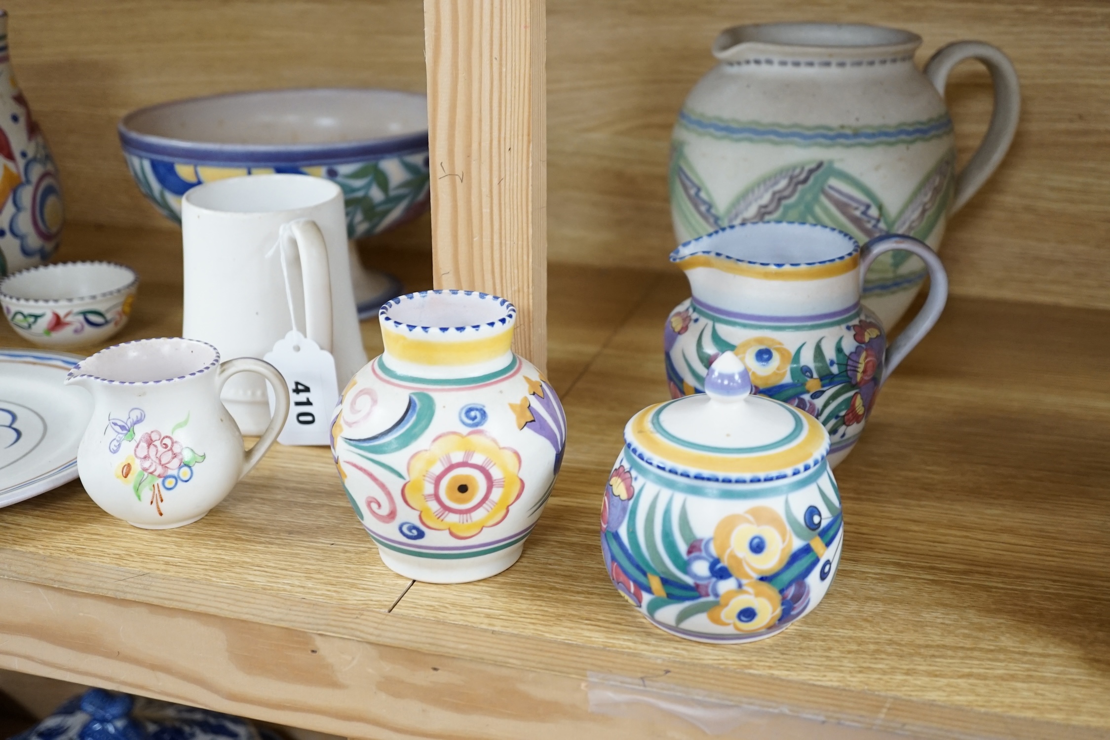 Eleven items of Poole pottery, from 1930’s to 50’s, including vases, jugs, mug and pedestal dish and pot and cover, tallest 19.5cm high. Condition - fair to good